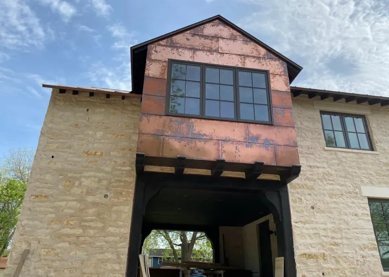 Copper metal panel facade on a stone building for Skylight Installation in Half Moon
